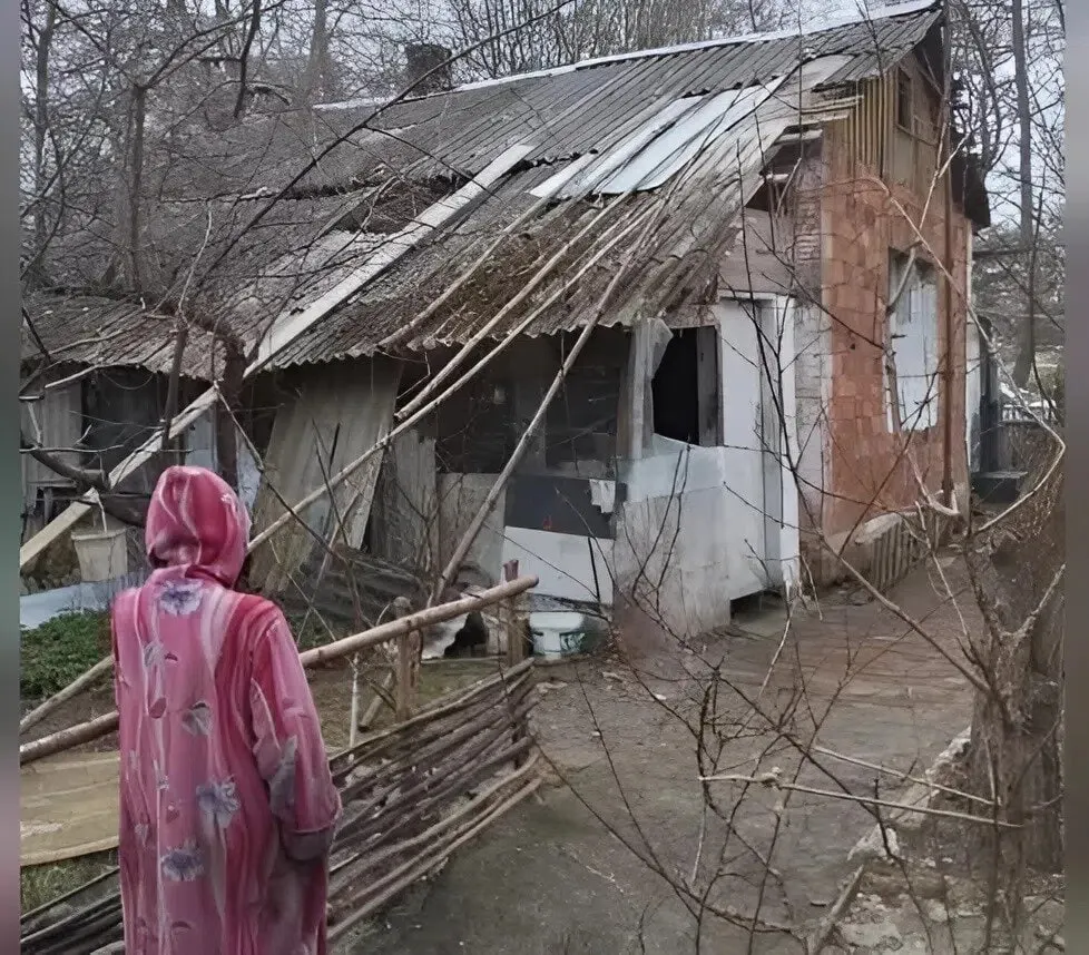 Её дом сняли с баланса в 2012 году — нет электричества, воды и канализации; отопление — дровами. После шторма крыша повреждена, соседи помогают, жители готовят жалобы в органы.